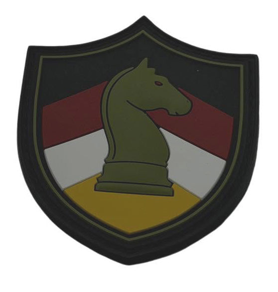 A shield-shaped military patch featuring a green chess knight on a yellow base, with red, white, and black diagonal stripes in the background.